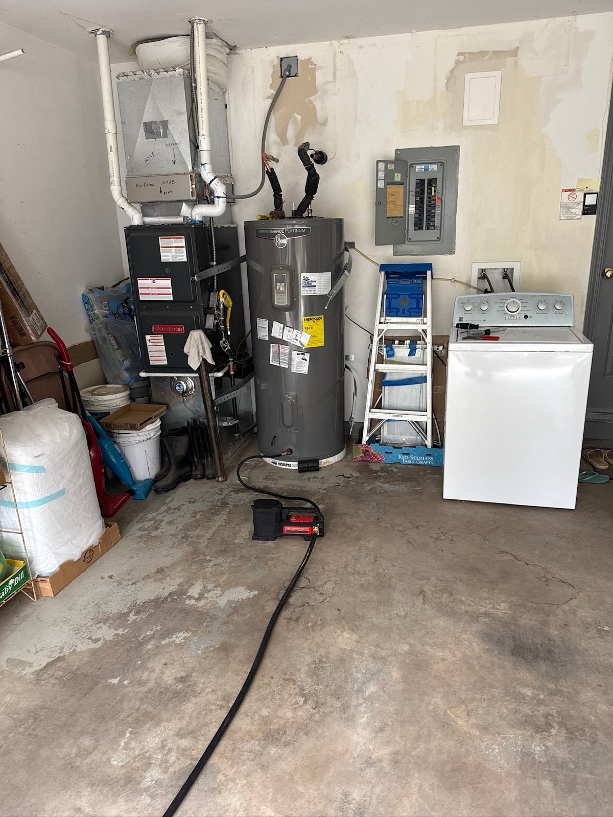 Wide shot of completed water heater replacement in Sellwood garage showing full workspace